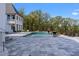 Backyard pool with stone paver patio and integrated fire bowls overlooking mature trees at 4100 Oak Hill Rd, Douglasville, GA 30135