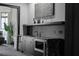 Modern wet bar with marble countertops, a built-in microwave and wine refrigerator at 4100 Oak Hill Rd, Douglasville, GA 30135