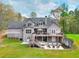 Expansive back of the house features a patio with furniture, a deck, and a well-maintained yard at 4539 Tiffany Ln, Loganville, GA 30052