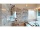 Beautiful shower features an elegant tile surround, glass door, multiple shower heads, and a window to view the spa tub at 4539 Tiffany Ln, Loganville, GA 30052