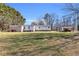 View of the back of the home featuring a spacious yard and storage sheds at 8989 E Cherokee Dr, Canton, GA 30115