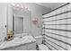 Cozy bathroom featuring a modern vanity, decorative mirror, and stylish black and white shower curtain at 951 Orchard Mill Ln, Lawrenceville, GA 30043