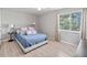 Bright bedroom with a comfortable bed, large window, and light-colored hardwood floors at 951 Orchard Mill Ln, Lawrenceville, GA 30043