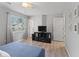 Spacious bedroom featuring a blue bedspread, TV, modern ceiling fan, and hardwood floors at 951 Orchard Mill Ln, Lawrenceville, GA 30043