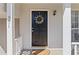 Inviting front entrance with a black door adorned with a wreath, complemented by a cozy porch setting at 951 Orchard Mill Ln, Lawrenceville, GA 30043