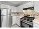 Modern kitchen featuring stainless steel appliances and ample countertop space at 951 Orchard Mill Ln, Lawrenceville, GA 30043