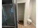 Bathroom featuring a glass-enclosed shower, a toilet, and a walk-in closet with shelving for optimal storage at 108 Deer Xing, Temple, GA 30179