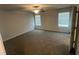 Spacious bedroom with neutral carpet, ceiling fan, and natural light from two windows at 108 Deer Xing, Temple, GA 30179