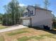 Side view of a two-story home with light gray siding, dark shutters, and a spacious driveway at 108 Deer Xing, Temple, GA 30179