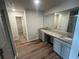 Well-lit main bathroom with double sink vanity, granite countertop, wood-look floors, glass shower, and walk-in closet at 108 Deer Xing, Temple, GA 30179