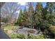 Landscaped backyard with a stone patio, mature trees, and outdoor seating at 1214 Oglethorpe Ne Ave, Brookhaven, GA 30319