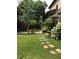 Backyard showcasing stone patio and garden area and lush green grass at 1214 Oglethorpe Ne Ave, Brookhaven, GA 30319