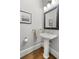 Elegant powder room featuring hardwood floors and a pedestal sink at 1214 Oglethorpe Ne Ave, Brookhaven, GA 30319