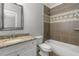 Bathroom featuring a granite countertop, tiled shower, and a framed mirror at 1214 Oglethorpe Ne Ave, Brookhaven, GA 30319