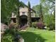 Charming home with a lush front yard, featuring a covered porch, mature landscaping, and a welcoming entrance at 1214 Oglethorpe Ne Ave, Brookhaven, GA 30319