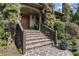 Inviting front porch with stone steps, a wooden handrail and a meticulously maintained garden at 1214 Oglethorpe Ne Ave, Brookhaven, GA 30319