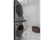 This laundry room features stacked washer and dryer, tile flooring, and storage at 1214 Oglethorpe Ne Ave, Brookhaven, GA 30319