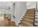 Staircase with carpeted treads and wood railing, adjacent to the living room at 1214 Oglethorpe Ne Ave, Brookhaven, GA 30319