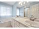 Bright bathroom featuring double sinks, soaking tub, and ample natural light at 170 Fairview Chase Rd, Covington, GA 30016