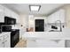 Bright kitchen featuring white cabinets, black appliances, tile floors, and breakfast bar at 170 Fairview Chase Rd, Covington, GA 30016