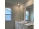 Bright bathroom features double sinks, framed mirrors, and white cabinets at 202 Groveton Ct, Euharlee, GA 30145