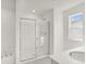 Modern bathroom featuring a tub and a glass-enclosed shower, illuminated by natural light at 202 Groveton Ct, Euharlee, GA 30145