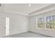Bright bedroom featuring neutral walls, gray carpet, and windows with backyard views at 202 Groveton Ct, Euharlee, GA 30145