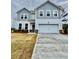 Charming two-story home featuring blue and grey accents, a two-car garage, and freshly laid sod at 202 Groveton Ct, Euharlee, GA 30145
