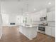 Modern kitchen with stainless steel appliances, white cabinets, and an island opens to living area at 202 Groveton Ct, Euharlee, GA 30145