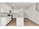 Modern kitchen features a center island, sleek white cabinetry, stainless steel appliances, and granite countertops at 202 Groveton Ct, Euharlee, GA 30145