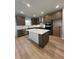 Well-lit kitchen featuring stainless steel appliances, quartz countertop island, and hardwood flooring at 3166 Morris Hills Dr, Dacula, GA 30019