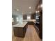 A well-lit kitchen with stainless steel appliances, quartz countertop island, and hardwood flooring at 3166 Morris Hills Dr, Dacula, GA 30019