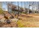 Expansive backyard featuring mature trees, a fire pit, and multi-level deck, perfect for outdoor living at 4240 Agard St, Cumming, GA 30040