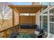 Relaxing backyard hot tub with wooden pergola and comfortable seating area overlooking the natural scenery at 4240 Agard St, Cumming, GA 30040