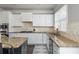 A kitchen with granite countertops, stainless steel appliances, mosaic backsplash, and a patterned rug at 4240 Agard St, Cumming, GA 30040