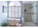 Relaxing bathroom featuring soaking tub, glass enclosed shower, and shuttered window at 408 Hickory Fairway Ct, Woodstock, GA 30188