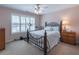 Bedroom features a ceiling fan, large window with plantation shutters, and exercise bike at 408 Hickory Fairway Ct, Woodstock, GA 30188