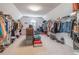 This walk-in closet features shelving, lots of hanging clothes, and carpeted flooring at 408 Hickory Fairway Ct, Woodstock, GA 30188