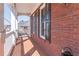 Covered brick porch with brick floor and white railing offers a place to unwind at 408 Hickory Fairway Ct, Woodstock, GA 30188