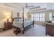 This main bedroom boasts tray ceilings, a ceiling fan, and a four-poster bed at 408 Hickory Fairway Ct, Woodstock, GA 30188