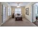 Bright sitting area with shuttered windows, neutral walls, neutral carpet, and a sofa and trunk at 408 Hickory Fairway Ct, Woodstock, GA 30188