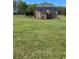 Large backyard with a spacious lawn that leads to a stately brick home with a wooden deck at 641 Freeman Brock Rd, Auburn, GA 30011