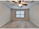 Bedroom featuring a ceiling fan, plush carpet, and a window overlooking the neighborhood at 641 Freeman Brock Rd, Auburn, GA 30011