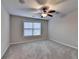 Bedroom with plush carpet, ceiling fan, and a window overlooking the neighborhood at 641 Freeman Brock Rd, Auburn, GA 30011