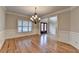 Charming dining room featuring wainscoting, a chandelier, and a glimpse of the front door, welcoming guests at 641 Freeman Brock Rd, Auburn, GA 30011