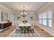 Elegant dining room featuring a modern chandelier, ample natural light, and stylish decor at 641 Freeman Brock Rd, Auburn, GA 30011