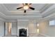 Bright and spacious main bedroom featuring a tray ceiling, ceiling fan, and elegant fireplace at 641 Freeman Brock Rd, Auburn, GA 30011