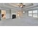 Spacious main bedroom boasts a fireplace, tray ceiling with fan, and ample natural light from the large windows at 641 Freeman Brock Rd, Auburn, GA 30011