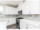 Well-lit kitchen features white cabinets, quartz countertops, stainless steel range, and modern backsplash at 2715 Stream Valley Lane Nw Nw Cir, Atlanta, GA 30318