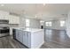 Open concept kitchen with stainless steel appliances, grey cabinets, and large island overlooks the living area at 2715 Stream Valley Lane Nw Nw Cir, Atlanta, GA 30318